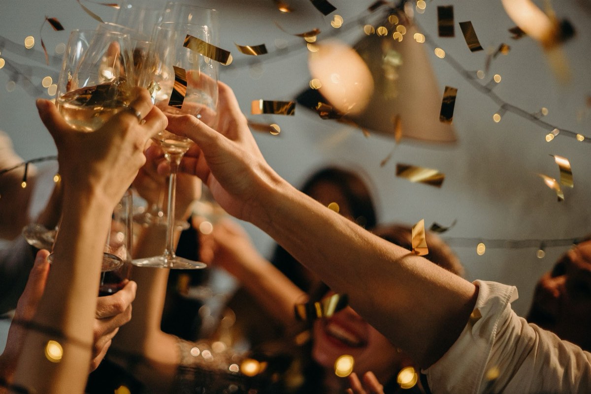 Gruppe stößt mit Sekt und Konfetti an